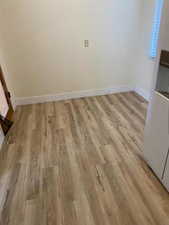 Unfurnished room with light wood-type flooring and baseboards