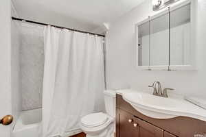 Full bathroom with vanity, toilet, and shower / bath combo with shower curtain