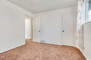 Unfurnished bedroom featuring carpet flooring and baseboards