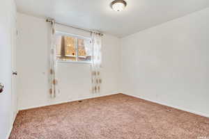 Spare room with carpet and baseboards