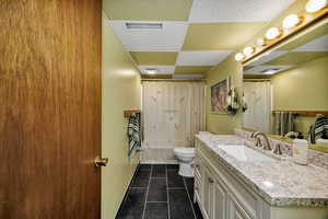 Full bathroom with vanity, toilet, tile patterned flooring, and shower / bath combo
