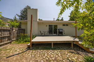 Rear view of property with a chimney and a deck