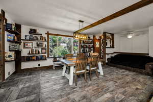 Dining room with a textured ceiling, ceiling fan, dark wood-style flooring, and a chandelier
