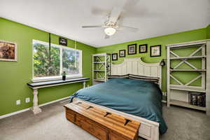 Bedroom with carpet flooring, baseboards, and ceiling fan