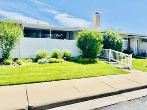 Exterior view of the townhome with walkway and fenced patio.
