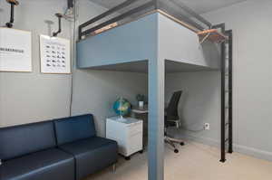 Bedroom with carpet floors, baseboards, and an office area