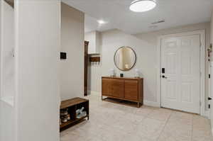 Tiled foyer featuring baseboards