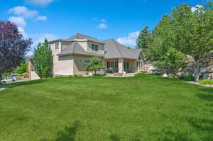 Rear view of property featuring stucco siding and a lawn