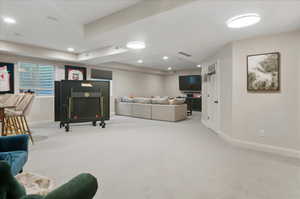 Living area with carpet flooring, baseboards, and recessed lighting