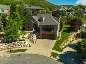 View of front of house with brick siding, stairs, driveway, an attached garage, and a front yard