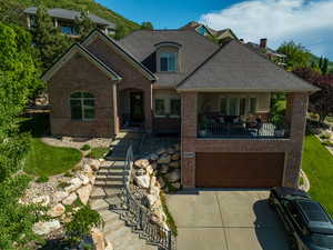 View of front facade featuring brick siding, concrete driveway, and a garage