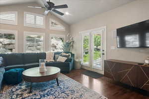 Living room featuring wood finished floors, vaulted ceiling, and ceiling fan