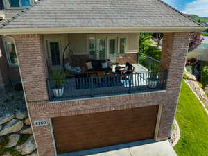 View of patio / terrace with a balcony, an attached garage, and driveway