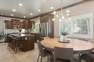 Dining area with ornamental molding, a chandelier, recessed lighting, and light tile patterned floors