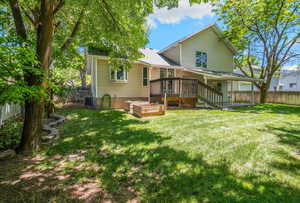 Back of house with a deck, a garden, and cooling unit