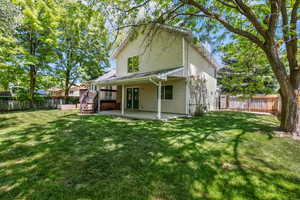 Rear view of property featuring a patio, a wooden deck, and stairway
