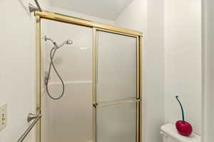 Full bath featuring an enclosed shower and toilet