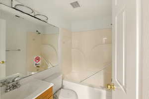 Bathroom featuring vanity, shower / washtub combination, and toilet