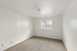 Unfurnished room with carpet flooring and baseboards