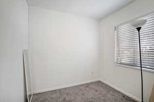 Carpeted spare room with baseboards
