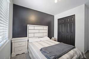 Bedroom featuring carpet flooring, baseboards, and a closet