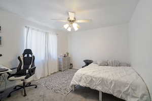Carpeted bedroom featuring ceiling fan and baseboards