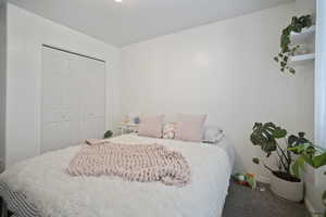 Bedroom with carpet floors, a closet, and baseboards