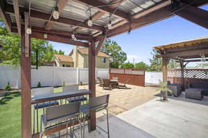 Fenced backyard featuring outdoor dining area, a patio area, and ceiling fan