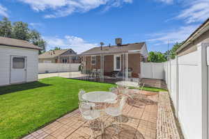Rear view of house with a patio area, entry steps, brick siding, an outdoor structure, and outdoor dining space