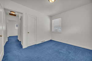 Unfurnished bedroom with carpet flooring and baseboards
