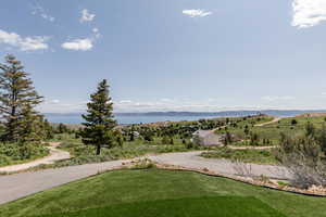 View of yard with asphalt driveway and a water and mountain view