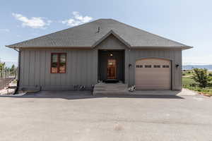 View of front of property featuring a shingled roof and board and batten siding