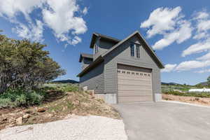 View of side of property with a garage and driveway
