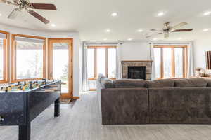 Living area with ceiling fan, recessed lighting, a fireplace, plenty of natural light, and baseboards