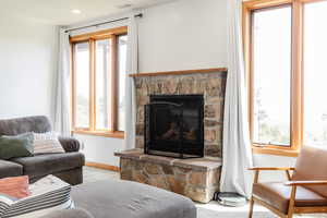 Living room featuring healthy amount of natural light, baseboards, and a fireplace