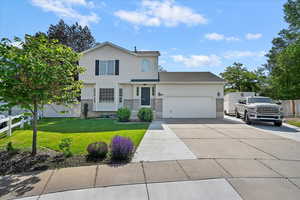 View of front of property with concrete driveway, an attached garage, and full fence