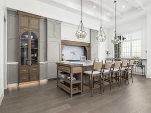 Kitchen featuring wood finished floors, a large island, a kitchen breakfast bar, recessed lighting, and decorative light fixtures