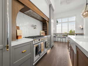 Kitchen with range with two ovens, gray cabinets, light countertops, dark wood-type flooring, and pendant lighting