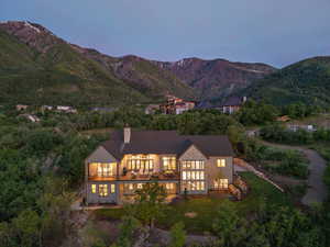 Rear view of property with a balcony, a mountain view, and a chimney
