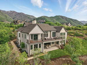 Rear view of house featuring a patio, a mountain view, cooling unit, a chimney, and roof with shingles