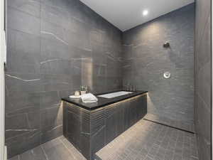 Bathroom featuring tile walls, a sink, tile patterned floors, a garden tub, and tiled shower