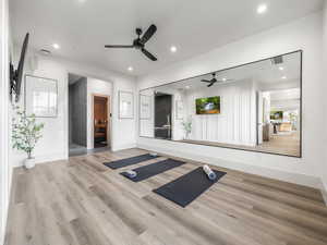 Workout area featuring ceiling fan, baseboards, wood finished floors, and recessed lighting