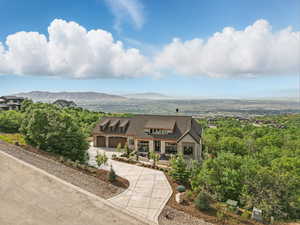 View of front of home featuring curved driveway, a mountain view, and a chimney