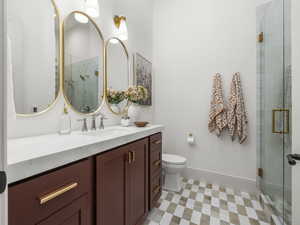 Full bath featuring vanity, tile patterned floors, a shower stall, and toilet