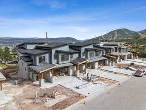 View of front facade featuring roof with shingles, a mountain view, and stone siding