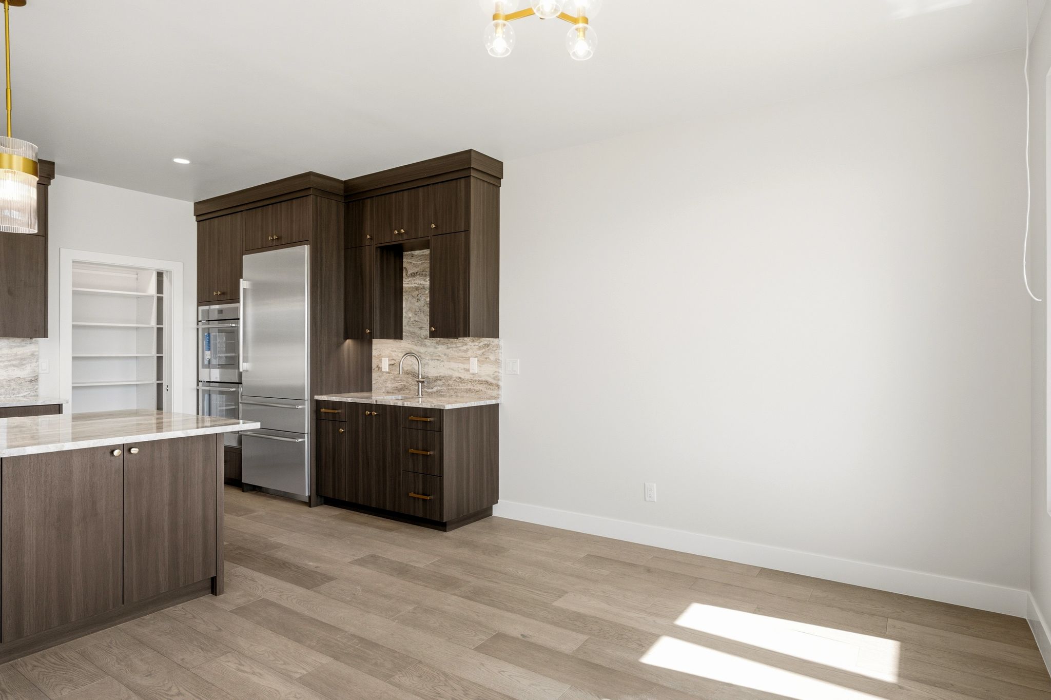 Kitchen featuring dark wood-finish cabinetry, stainless steel appliances, and a central island with a light-toned countertop