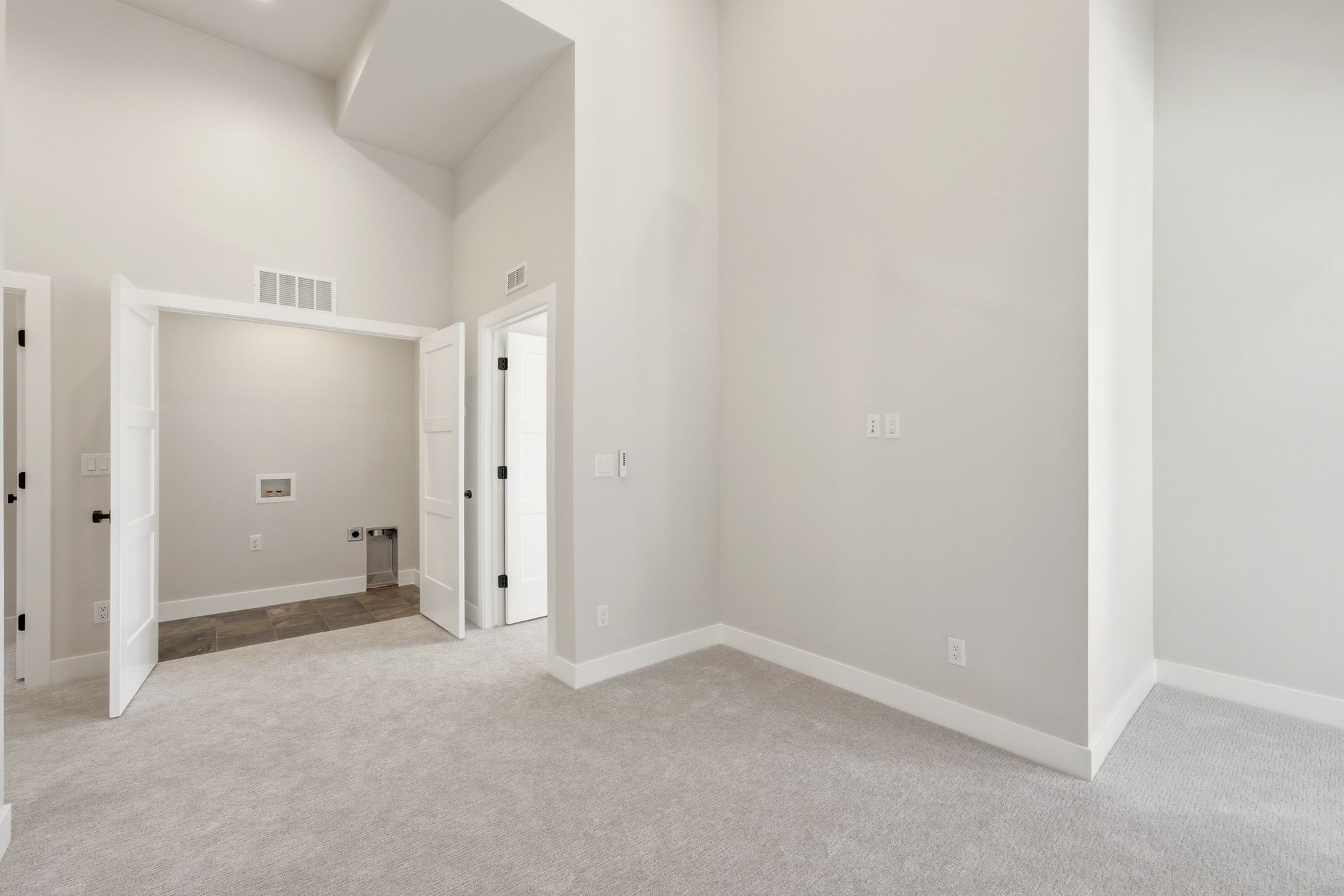 Laundry hookups within a dedicated alcove featuring tile flooring
