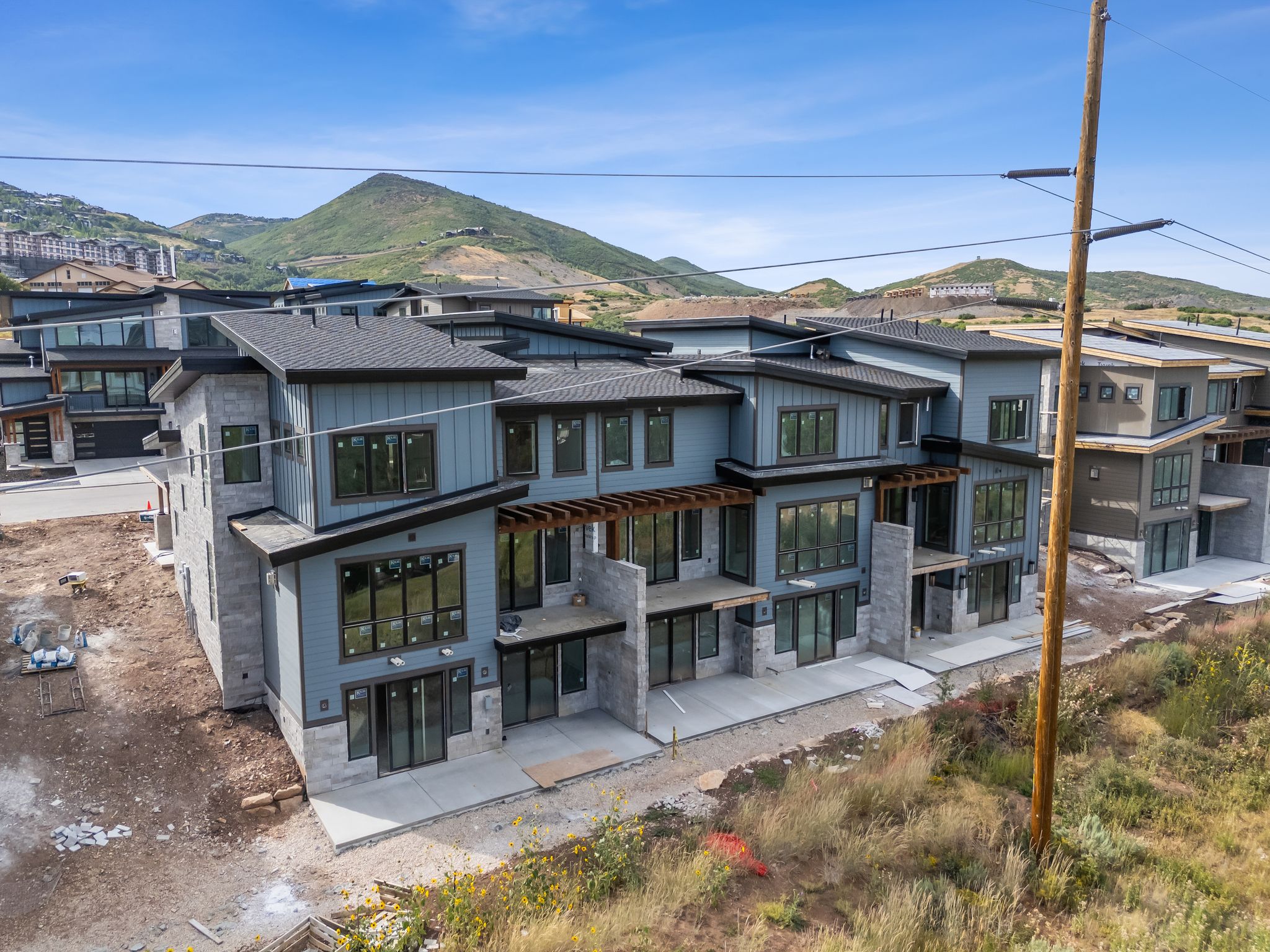 Back of property with a residential view, stone siding, a mountain view, and board and batten siding