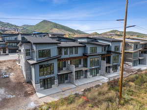 Back of property with a residential view, stone siding, a mountain view, and board and batten siding