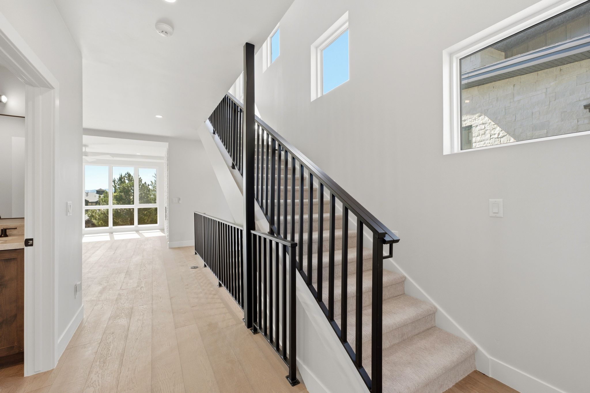 Modern staircase with black metal railings and carpeted treads